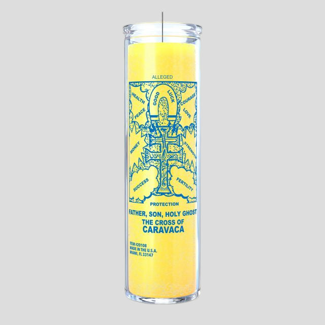 Yellow candle with Cross of Caravaca on it on a grey background.