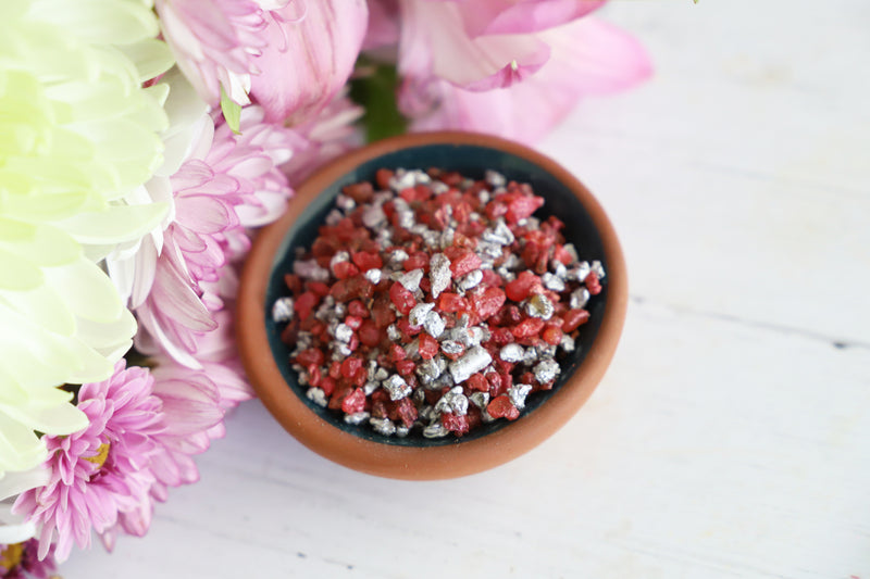 Bowl of resin incense grains on a white background with flowers