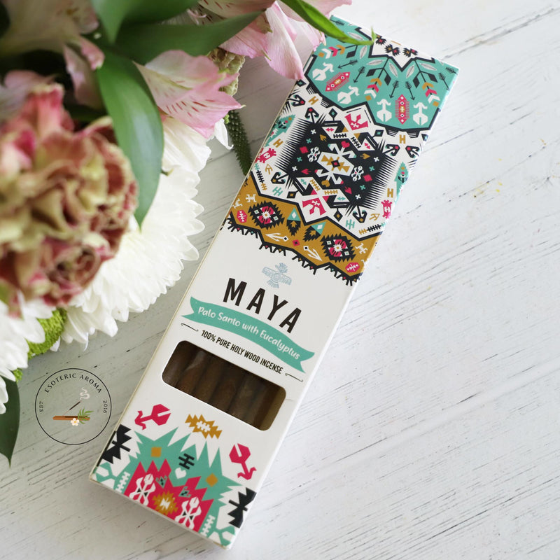 Maya Palo Santo with Eucalyptus packaging on white background with fresh flowers on the side.