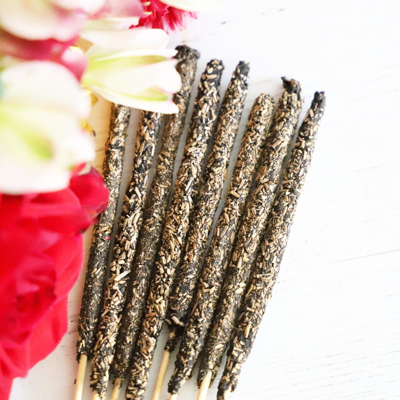 Herbal incense sticks on a white background with red, white and green flowers.