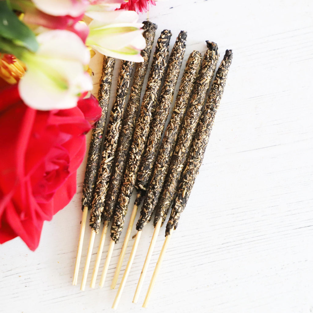 Herbal incense sticks on a white background with red, white and green flowers.
