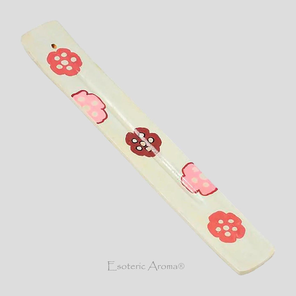 Painted flowers on an incense burner on a neutral background.