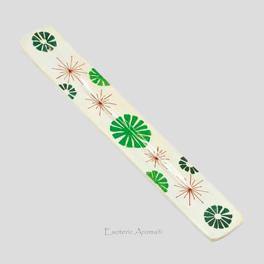 Incense holder with red starbursts and green abstract flowers on a grey background