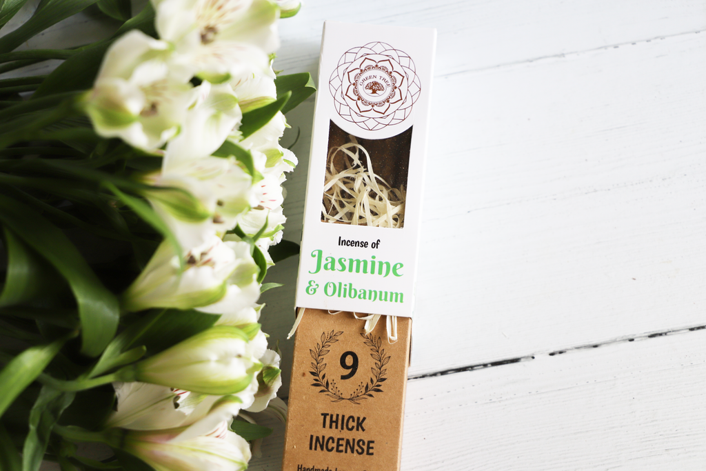 Green Tree Incense of Jasmine & Olibanum package on white table with green leaves and white flowers.