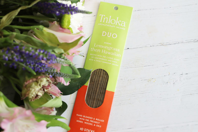 Triloka Duo Lmeongrass then Hawaiian incense packaging with flowers on a white background