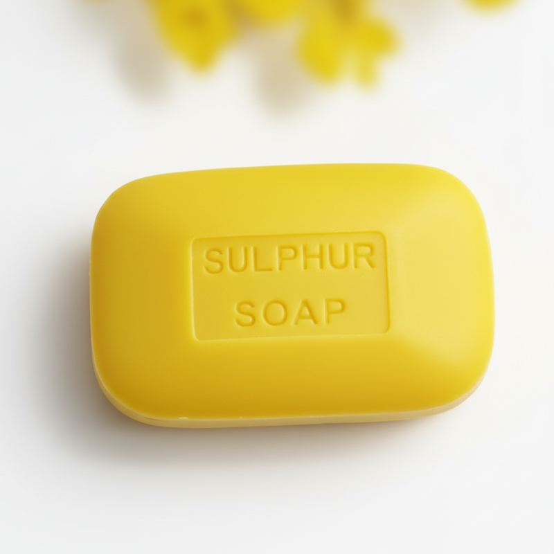 Yellow bar of sulfur soap on a white background with yellow flowers.