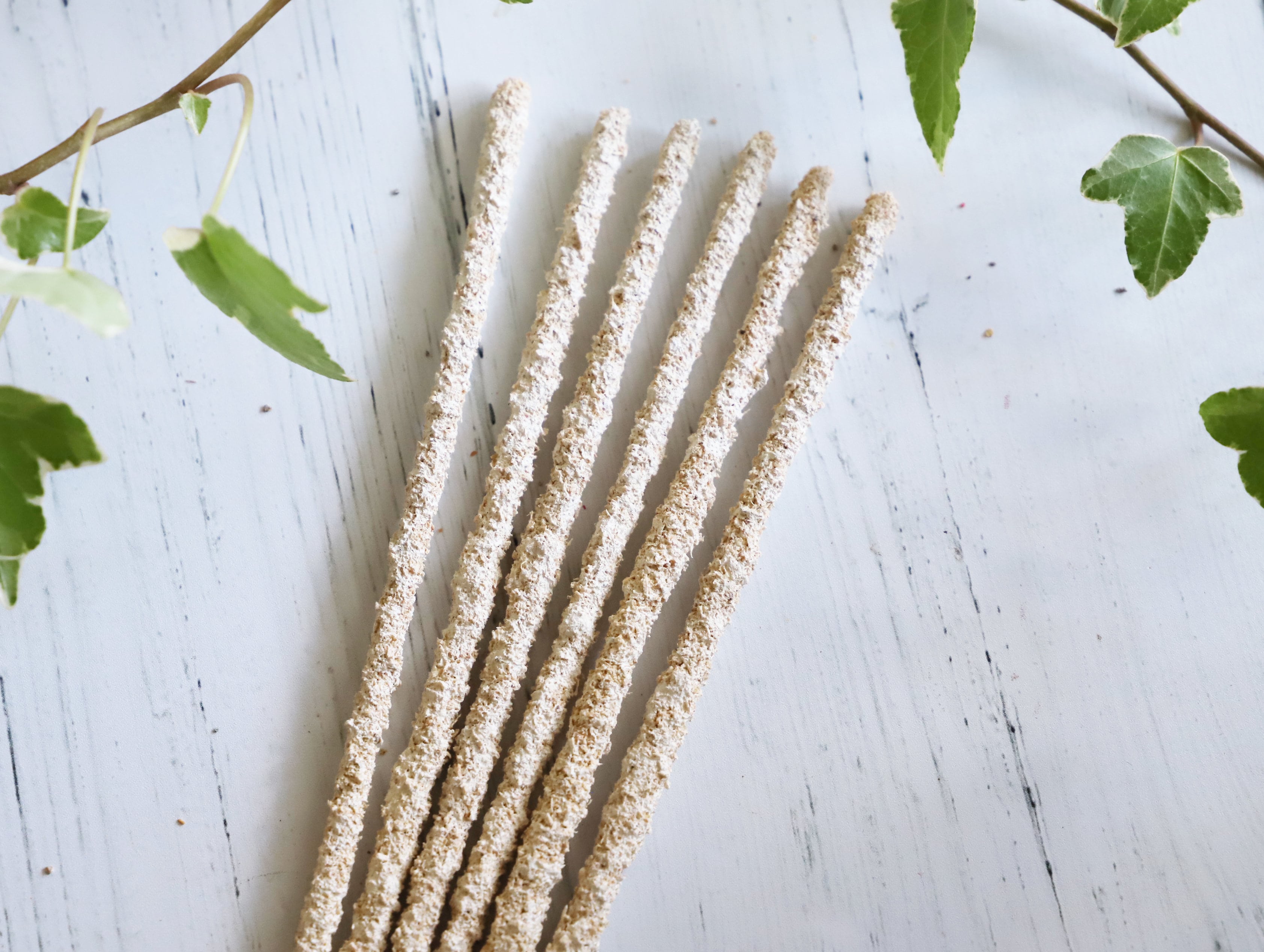 Mayan copal incense sticks standing in a wooden bowl with a blurred altar background